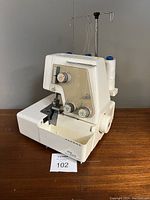 Front view of machine showing housing, tension dials and thread stand