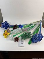 Overview of all eleven glass flowers laid out on white background