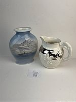 Photo showing Royal Copenhagen vase with mountainous landscape and the Wedgwood jug with sculpted handle side by side.