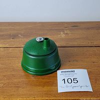 Photo of the green metal Tru-Point pencil pointer with a silver adjustment knob on top, sitting on a wood surface.