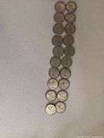 Photo showing all 20 Canadian quarters arranged in two columns, displaying the obverse and reverse sides.