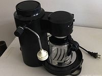 Front angle of Braun Express coffee maker showing milk frother attachment and glass carafe.