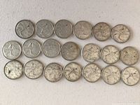 20 Canadian quarters laid out with caribou side showing.