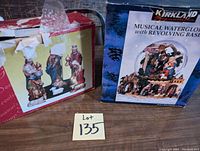 Photo showing Kirkland musical waterglobe box and Christmas nativity set box with figurines partially visible