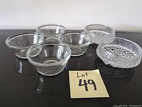 Photo of all 6 bowls arranged on a black surface, showing 4 smooth clear glass bowls and 2 textured clear glass bowls.