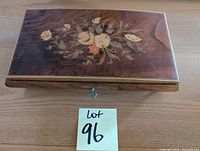 Top view of wooden jewellery box showing detailed floral inlay on lid with key lock and Lot number 96 tag.
