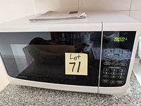 Front view of Emerson microwave oven on countertop with digital display showing 0:00 and keypad.