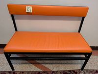 Front view of one orange vinyl and black metal bench seat