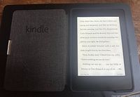Kindle Paperwhite device inside grey fabric cover showing text on screen.