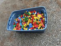 Large blue plastic bin filled with assorted LEGO blocks of various colors and sizes.