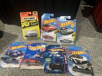 Lot of 7 die-cast cars still sealed on original cards, including 6 Hot Wheels and 1 Matchbox. Variety of sports car models including Lamborghini Diablo.