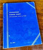 Blue soft cover folder titled 'Canadian Large Cent Collection 1858 to 1920' with corner wear and visible use marks.
