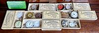 Overview of six Sandsteel boxes of mainsprings, Elgin tin, assorted parts on table