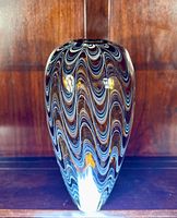 Front view of the large vintage art glass vase showing the wavy swirled pattern in black, white, and amber colors.