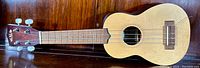 Full view of KA-158 Kala ukulele showing front body, fretboard, headstock with tuning pegs and strings.