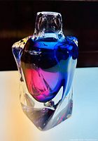 Frontal view of clear block-form vase with blue and pink internal swirls