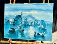 Front view of the signed oil on canvas painting showing the marine port scene with traditional sailing ships and the signature in the lower left corner.
