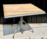 Full view of the drafting table showing beechwood top and metal base.