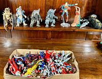 Cardboard box filled with over 20 red and silver Ultraman figures piled loosely