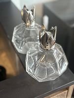 Pair of Maison Berger Cristal Blanc fragrance burners showing clear faceted glass with shiny silver metal tops