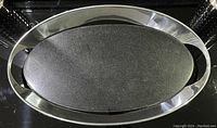 Oval polished stainless steel platter with a dark textured stone oval inset center, measuring about 48 cm long.