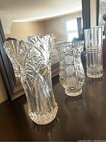 Three crystal decorative flower bases, showing detailed cut patterns and shapes