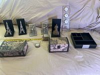 Full view of all items displayed on beige cloth background including bookends, decorative boxes, clock/barometer, tape measure, organizer tray.