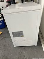 Side view of white Insignia chest freezer showing vent and control panel.