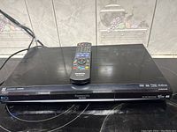 Front view of Panasonic Blu-Ray player with remote control placed on top.