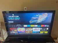 Front view of Samsung 46 inch smart TV on stand showing the active home screen with streaming apps visible.