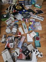 Overview of assorted miscellaneous merchandise including toys, household, and personal items spread on a wooden floor