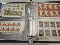 Photo showing pages of the album containing mint Russian stamps in blocks and strips on both left and right sides of the open binder.