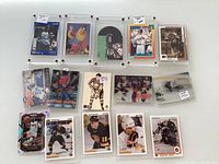Collection of sports trading cards displayed on a flat surface. Cards include various hockey and baseball players encased in clear plastic protective holders, arranged in three rows.