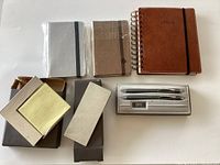 Photo showing the boxed Cross pen and pencil set with three new notebooks and two silver desk accessories.