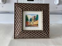 Framed watercolour painting showing the overall artwork and the decorative brown and white frame