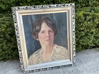 Full view of the framed oil portrait showing the woman in a light blouse against a dark background.