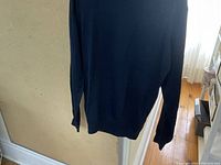 Back view of the ladies wool turtleneck sweater showing smooth fabric and overall length in natural lighting.