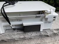 Rear and bottom side of Canon Pixma MG2920 printer showing power cord connection and paper feed mechanism.