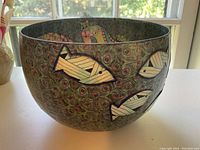 Exterior view of glass bowl showing green textured background with abstract fish motifs decorated in striped Zentangle patterns.