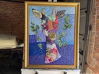 Framed fabric collage giraffe artwork showing full piece with gold frame and colorful giraffe design.