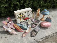 Full lot with all ceramic miniature shoes, ceramic purses, hat figurine, and shoe history book.