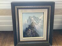 Framed oil painting showing full artwork and frame against a wall.