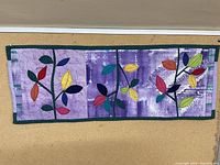 Full view of handmade purple table runner with detailed leaf appliqué and quilting
