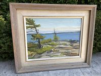 Framed vintage landscape oil painting photographed outdoors showing full view of artwork and frame