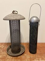 Front view of two metal bird feeders, displaying size and structure details.