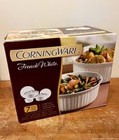 Box front showing CorningWare French White branding and images of dishes with food.