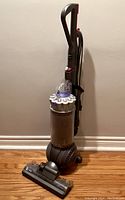 Full view of Dyson vacuum showing upright design, canister, main body, floor head, and handle.