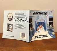 Front and back cover showing signatures of Robert Munsch on back flap and inside cover with biography and cartoon portraits.