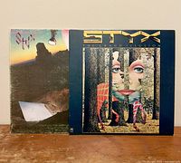 Front covers of Styx Cornerstone and The Grand Illusion vinyl LP records, showing album artwork and condition.