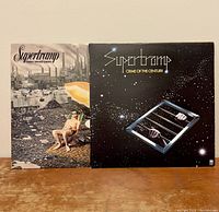 Front covers of two Supertramp vinyl records: Crisis? What Crisis? on the left featuring a man on a beach with industrial buildings, and Crime of the Century on the right featuring hands behind bars in space.